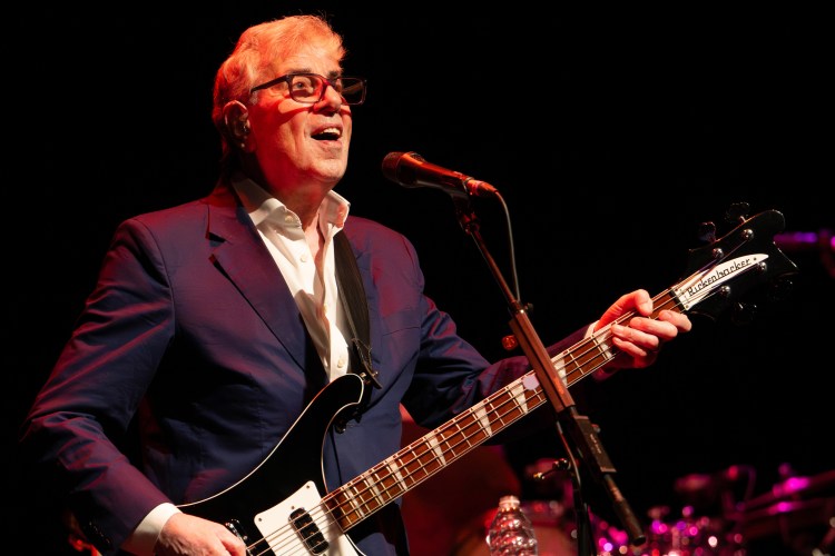 Graham Gouldman of 10cc performing on bass guitar.