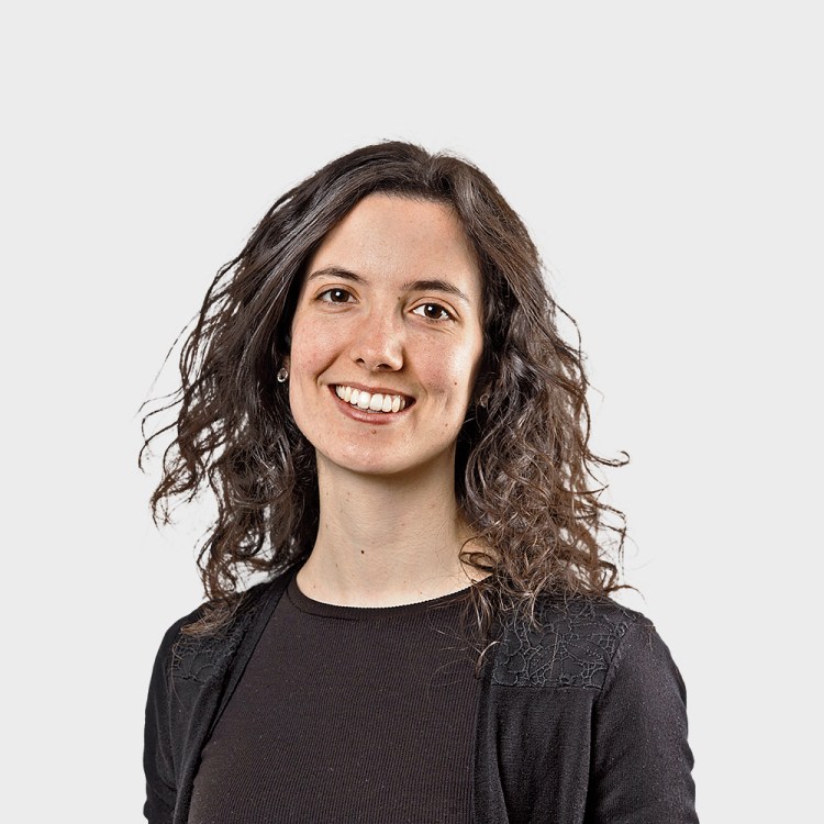 Portrait of a smiling woman with curly brown hair.