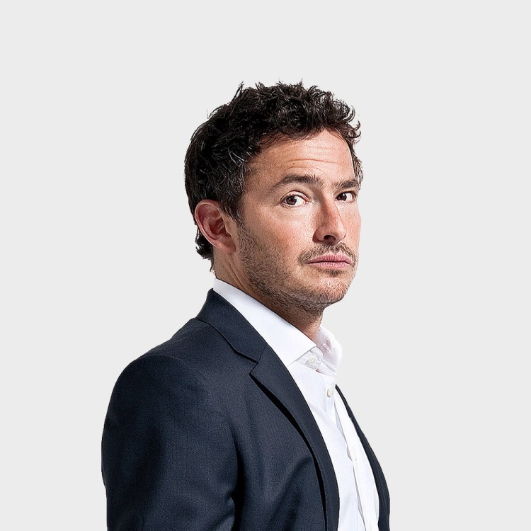 a man in a suit and white shirt is looking at the camera