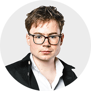 a young man wearing glasses and a black jacket